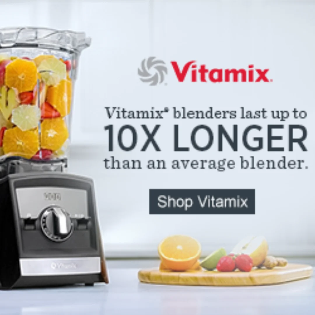 Vitamix blender filled with vibrant fresh fruits on clean background